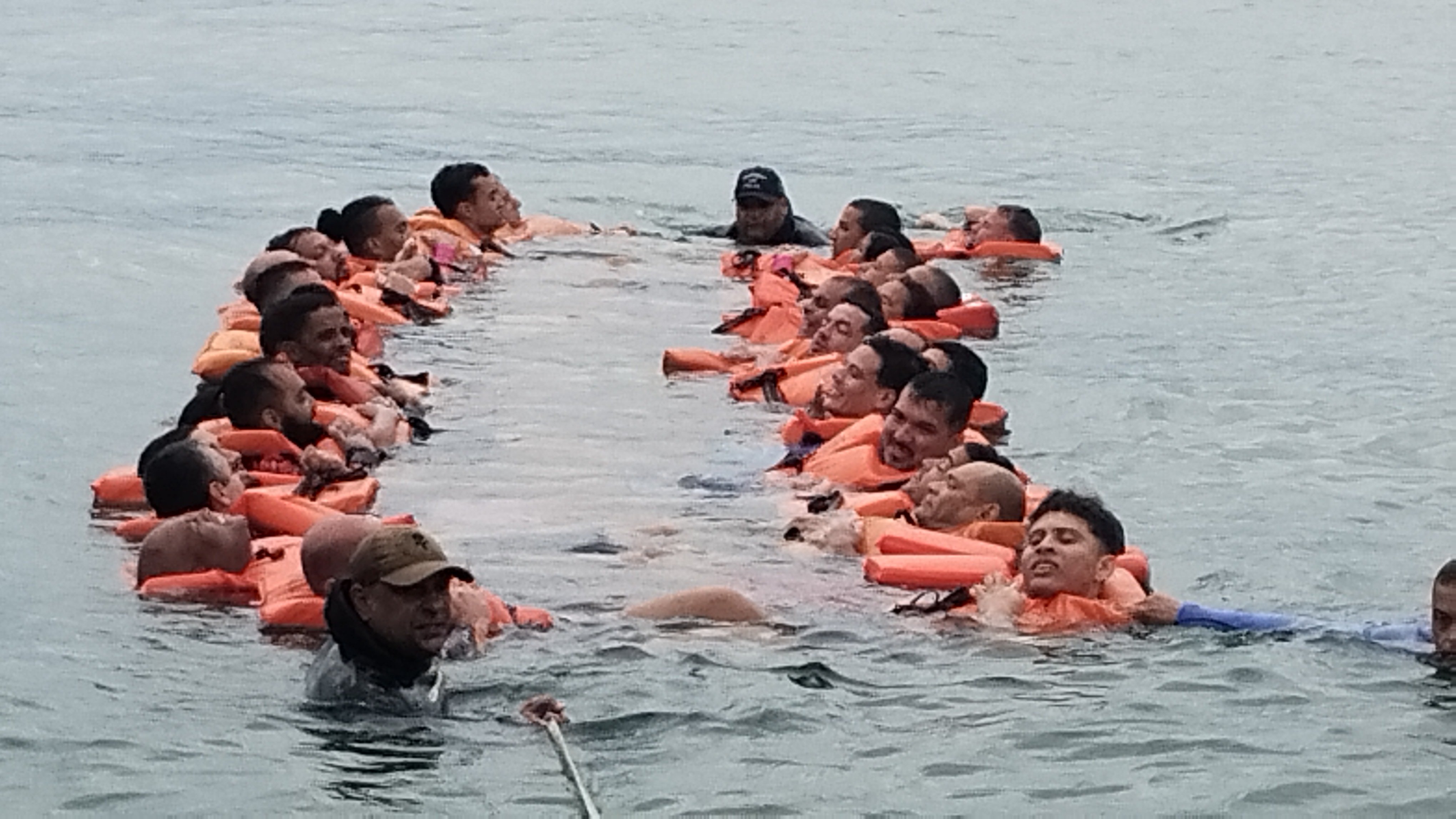 Alunos em formacao circular durante treinamento aquaviario na agua